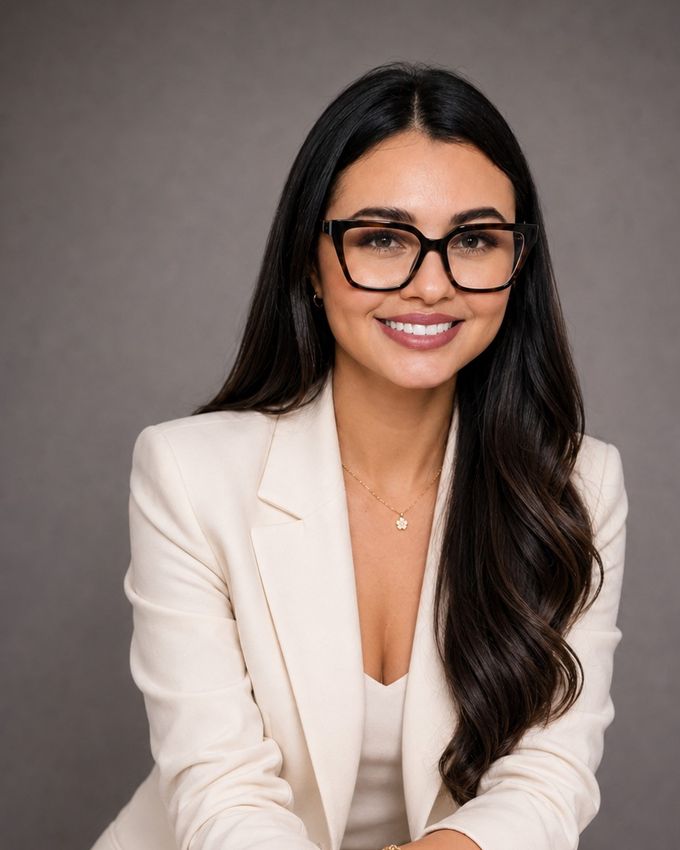 Margelys Melo sonriendo, con lentes de marco oscuro, cabello largo y blazer color marfil